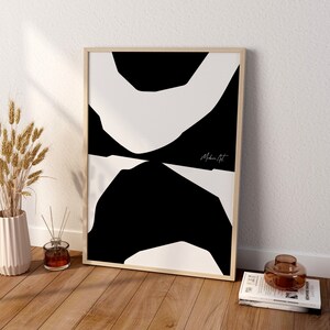 Op de afbeelding: Een zwart-witte abstracte kunstprint in een houten lijst. De print heeft een reeks overlappende vormen in een minimalistische stijl. De print is getiteld "Moderne Kunst".