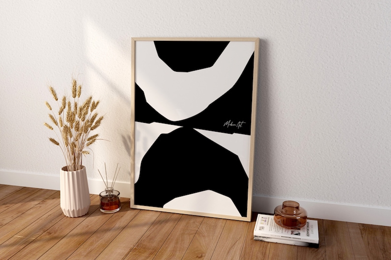 Op de afbeelding: Een zwart-witte abstracte kunstprint in een houten lijst. De print heeft een reeks overlappende vormen in een minimalistische stijl. De print is getiteld "Moderne Kunst".