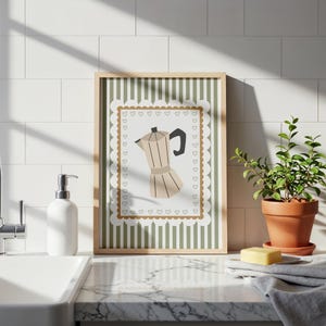 Peut inclure: Une affiche encadr&eacute;e repr&eacute;sentant une cafeti&egrave;re beige avec une poign&eacute;e noire, sur un fond &agrave; rayures vertes et blanches. L'affiche a une bordure festonn&eacute;e avec des motifs de c&oelig;ur. D&eacute;coration de cuisine.