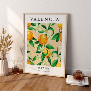 Może przedstawiać: Wydruk w ramie z akwarelową ilustracją kwiat&oacute;w pomarańczy i pomarańczy. Wydruk zawiera tekst "VALENCIA" u g&oacute;ry i "ESPA&Ntilde;A TIERRA DE NARANJAS" na dole.