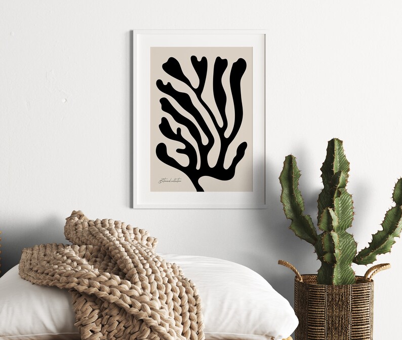 May include: A black and white abstract print of a stylized coral branch on a beige background. The print is framed in a white frame.