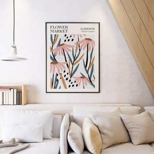 May include: A framed print with a floral design featuring pink flowers, green leaves, and black and gold accents. The print has the text "FLOWER MARKET LONDON COVENT GARDEN" at the top.