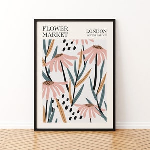 May include: A framed print with a floral design featuring pink flowers, green leaves, and black and brown accents. The text "FLOWER MARKET LONDON COVENT GARDEN" is printed at the top of the print.