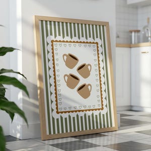 May include: A framed print featuring four brown coffee mugs on a white background with a scalloped border of hearts. The background has vertical green and white stripes, and the frame is light brown.