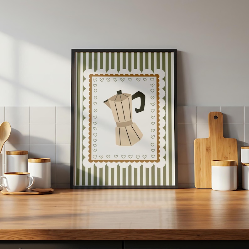 Peut inclure: Impression encadr&eacute;e repr&eacute;sentant une cafeti&egrave;re beige. L'&oelig;uvre est plac&eacute;e sur un fond blanc avec une bordure festonn&eacute;e orn&eacute;e de c&oelig;urs bruns. Le fond pr&eacute;sente des rayures verticales vertes. L'impression est dans un cadre noir.