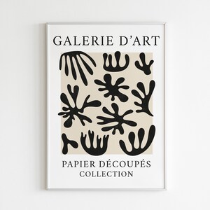 May include: A beige poster with black abstract shapes and the text "GALERIE D'ART PAPIER D&Eacute;COUP&Eacute;S COLLECTION".