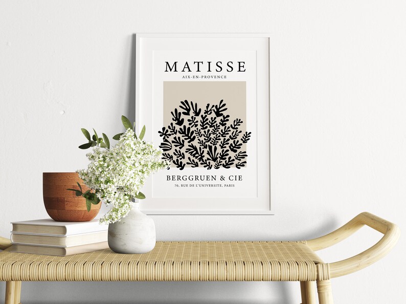 May include: A black and white art print featuring a stylized image of leaves in a beige background. The print has the text "MATISSE" at the top, "AIX-EN-PROVENCE" below it, and "BERGGRUEN & CIE" and "79, RUE DE L'UNIVERSITE, PARIS" at the bottom.