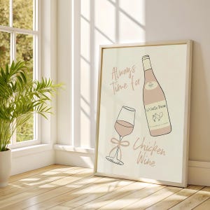 May include: A framed print with a pink wine bottle and glass design. The text reads "Always Time for Chicken Wine". The artwork is set against a light beige background. The print is in a light wooden frame.