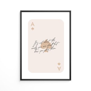 Puede incluir: Una carta de as de picas de color beige y marr&oacute;n con la cita "No se trata de las cartas que te reparten, sino de c&oacute;mo las juegas." impresa en ella.