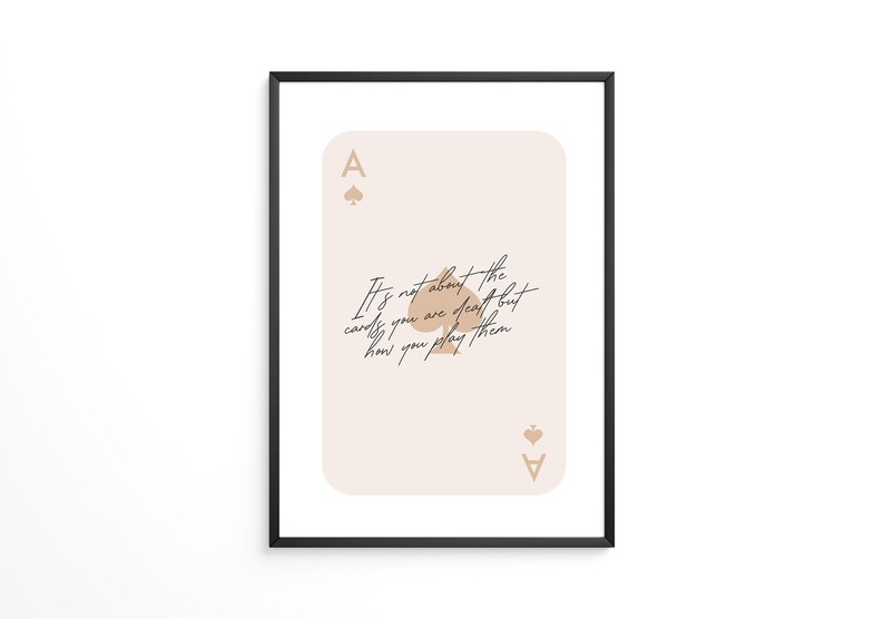 Puede incluir: Una carta de as de picas de color beige y marr&oacute;n con la cita "No se trata de las cartas que te reparten, sino de c&oacute;mo las juegas." impresa en ella.