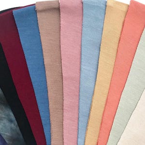 This is an image of our CPAP chin straps arranged in a fan shape, showcasing their different colors and textures.