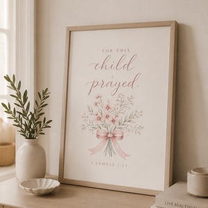 May include: A framed wall art print featuring the text "FOR THIS child I prayed." in a mix of serif and script fonts, with a watercolor illustration of a pink floral bouquet tied with a ribbon and the citation "1 SAMUEL 1:27" below.