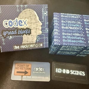 Może przedstawiać: Zestaw puzzli i kart "Codex Spread Blocks". Pudełko jest niebieskie z sylwetką puzzli i tekstem "codex spread blocks" i "the reckoning co". Dwie karty mają napisy "Point of No Return" i "Behind Scenes".