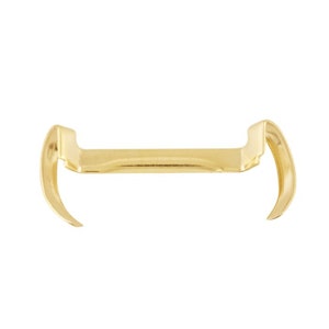 May include: Gold metal bracket with two curved ends. The bracket is designed to hold a shelf or other object.
