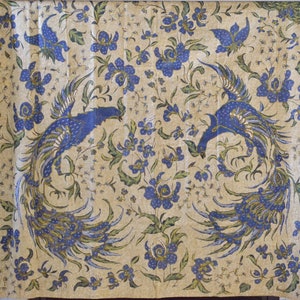 May include: A cream-colored fabric with a repeating pattern of blue and green peacocks and blue flowers. The fabric has a gold border.