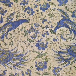 May include: A beige fabric with a blue and green floral pattern featuring two peacocks facing each other.