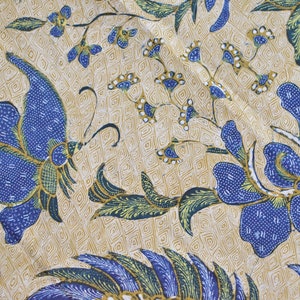 May include: A beige fabric with a blue and green floral pattern. The pattern features butterflies and flowers with intricate details.