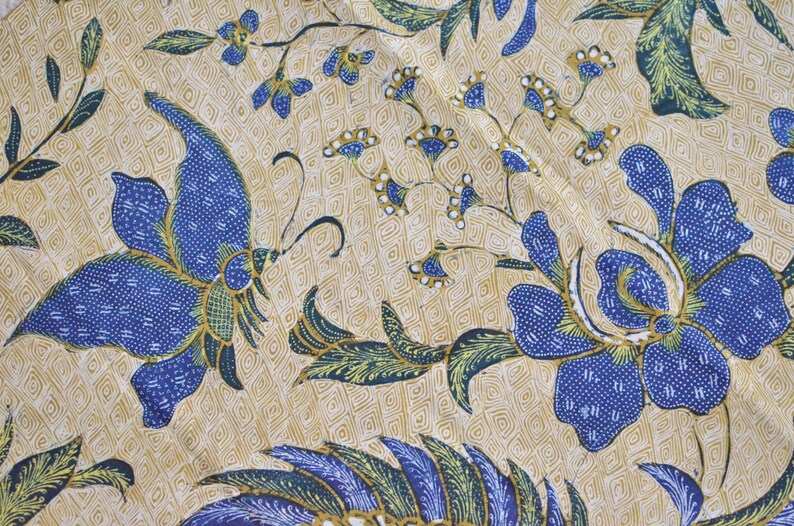 May include: A beige fabric with a blue and green floral pattern. The pattern features butterflies and flowers with intricate details.