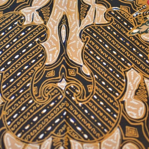 May include: A black fabric with a repeating pattern of gold and white stylized floral designs. The pattern is intricate and detailed, with a symmetrical design.