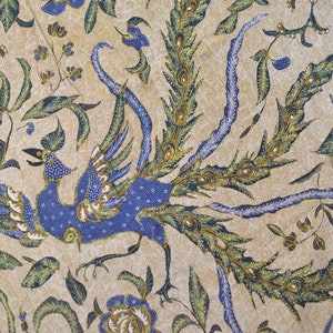 May include: A beige fabric with a blue and green peacock design. The peacock is depicted with its tail feathers spread out.