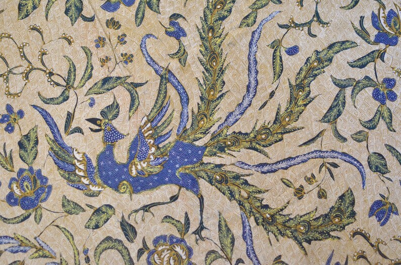 May include: A beige fabric with a blue and green peacock design. The peacock is depicted with its tail feathers spread out.