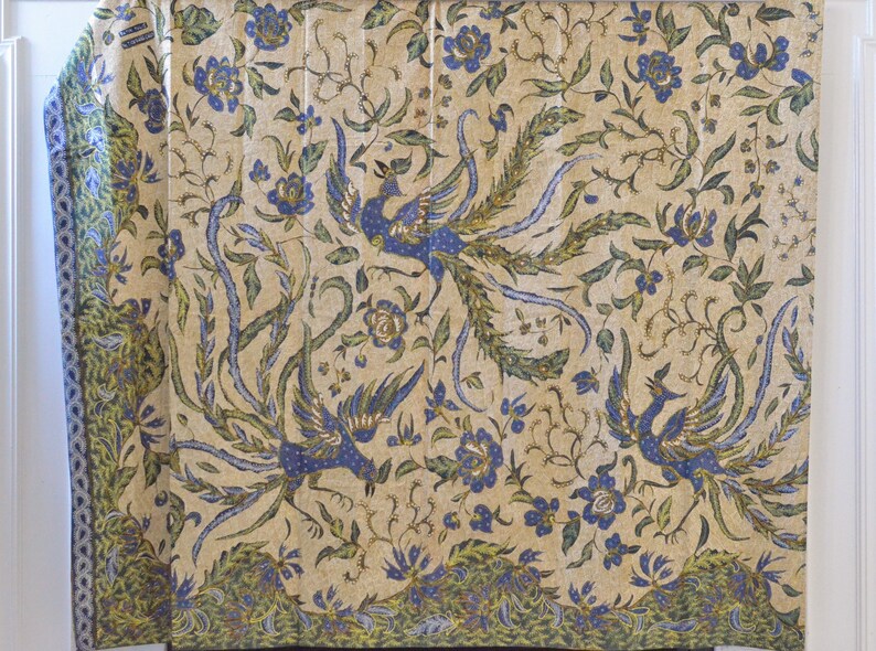 May include: A cream-colored fabric with a repeating pattern of blue and green peacocks and floral designs.