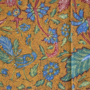 Könnte beinhalten: Ein brauner Stoff mit einem blauen und grünen Blumenmuster. Das Muster zeigt stilisierte Blumen, Blätter und Vögel.