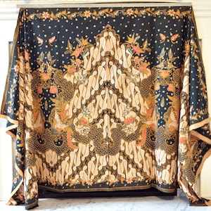 May include: A black and gold patterned fabric with a traditional Indonesian batik design. The fabric features intricate floral and geometric motifs.