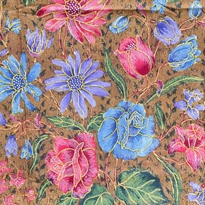 May include: A brown fabric with a floral pattern. The flowers are in shades of pink, blue, and green. The fabric has a subtle sheen.