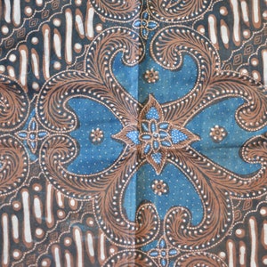 Könnte beinhalten: Ein blauer und brauner Batikstoff mit einem floralen Muster. Der Stoff hat einen weißen Hintergrund mit braunen und blauen Designs.