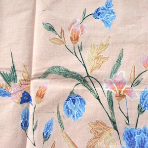 Könnte beinhalten: Ein rosa Stoff mit einem Blumenmuster. Die Blumen sind blau, rosa und orange. Der Stoff hat ein leichtes, luftiges Gefühl.