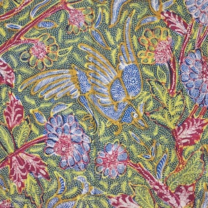 Könnte beinhalten: Ein blauer und weißer Vogel mit gelben Flügeln fliegt über einem grünen Hintergrund mit roten, weißen und blauen Blumen. Der Hintergrund ist mit einem Muster aus kleinen weißen Punkten bedeckt.