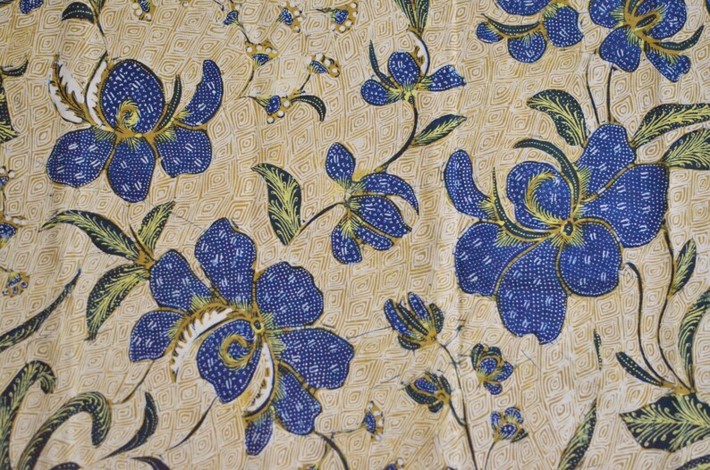 May include: A beige fabric with a repeating pattern of blue and yellow flowers. The flowers are stylized and have a geometric design.