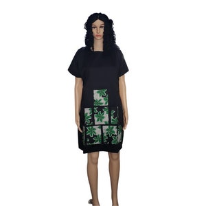 May include: A black short-sleeved dress with a green and white floral pattern on the front.