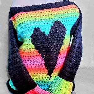 Pu&ograve; includere: Un top all'uncinetto arcobaleno con un design a forma di cuore nero. Il top ha una scollatura ampia e maniche lunghe.