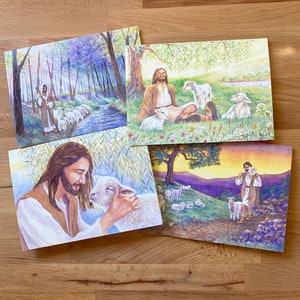May include: Four watercolor paintings depicting Jesus with sheep. The first shows Jesus walking through a forest with a flock of sheep. The second shows Jesus sitting with three sheep in a field. The third shows Jesus holding a sheep close to his face. The fourth shows Jesus walking with a sheep on a hillside.