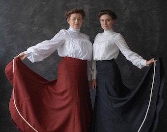 Puede incluir: Dos mujeres con blusas blancas y faldas largas. La mujer de la izquierda lleva una falda color burdeos con ribete blanco. La mujer de la derecha lleva una falda negra con ribete blanco. El texto "gibson_girl_dress" es visible en la esquina inferior derecha de la imagen.