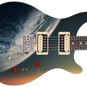 May include: A dark blue electric guitar with a custom design featuring a photo of Earth from space. The guitar has a cream-colored pickguard and two black humbucker pickups.