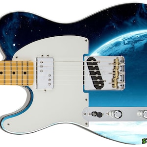 May include: A white electric guitar with a blue and black space-themed design featuring a planet and stars. The guitar has a white pickguard and gold hardware.