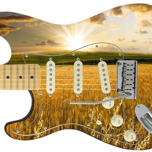 May include: A black electric guitar with a sunset and field of wheat design. The guitar has a maple neck and a rosewood fretboard.