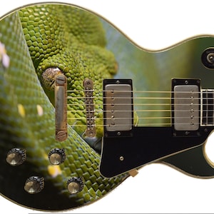 May include: A black electric guitar with a green snake skin design. The guitar has a single cutaway body, a rosewood fretboard, and gold hardware.