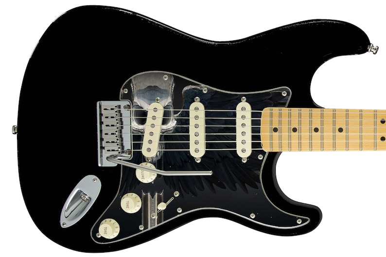 Pu&ograve; includere: Chitarra elettrica nera con un battipenna a forma di teschio e ali. La chitarra ha una tastiera in acero e hardware cromato.