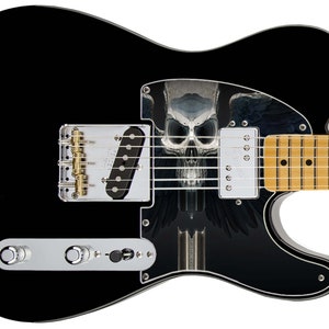 Pu&ograve; includere: Chitarra elettrica nera con una grafica di teschio e ali sul corpo. La chitarra ha una tastiera in acero e hardware dorato.