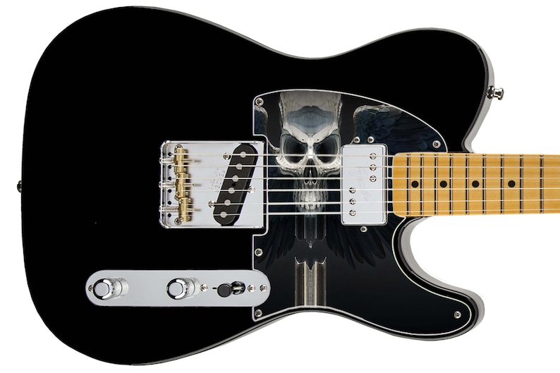 Pu&ograve; includere: Chitarra elettrica nera con una grafica di teschio e ali sul corpo. La chitarra ha una tastiera in acero e hardware dorato.