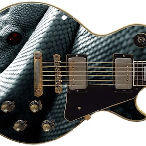 Può includere: Una chitarra elettrica nera con un design a pelle di serpente. L'occhio del serpente è rosso e la chitarra ha hardware dorato.