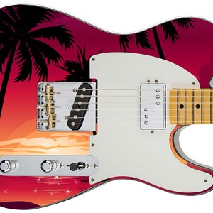 May include: A white electric guitar with a red and orange sunset graphic featuring palm trees. The guitar has a white pickguard and gold hardware.