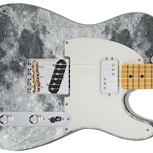 May include: A black and white electric guitar with a moon-like finish. The guitar has a white pickguard and gold hardware.
