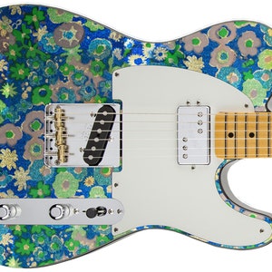 Può includere: Una chitarra elettrica blu con un motivo floreale e hardware dorato. La chitarra ha un battipenna bianco e una tastiera in acero.