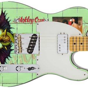 Puede incluir: Una guitarra eléctrica verde con una golpeador blanco. La guitarra tiene un diseño personalizado con un patrón de azulejos verdes y blancos, un dragón y el texto "Motley Crue".