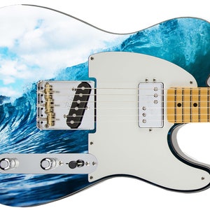 May include: A white electric guitar with a blue and white wave design. The guitar has a black pickguard and a maple neck.
